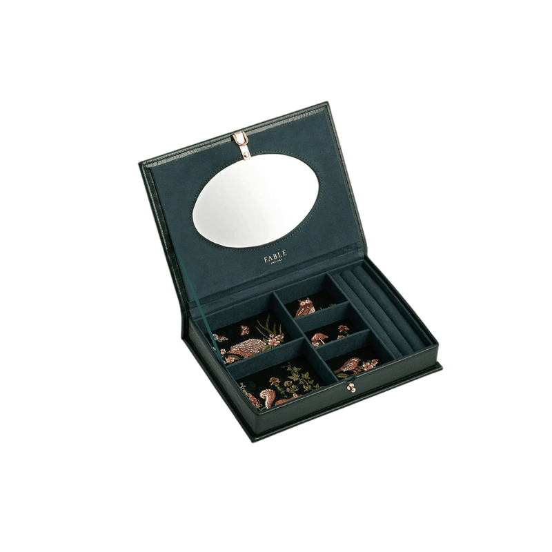 Open Fable England large forest-green jewellery box showing woodland embroidery, mirror, compartments and ring holders