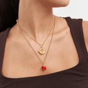 Fable England apple necklace worn with a shorter gold pendant necklace for a layered jewellery look