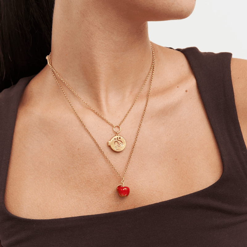 Fable England apple necklace worn with a shorter gold pendant necklace for a layered jewellery look