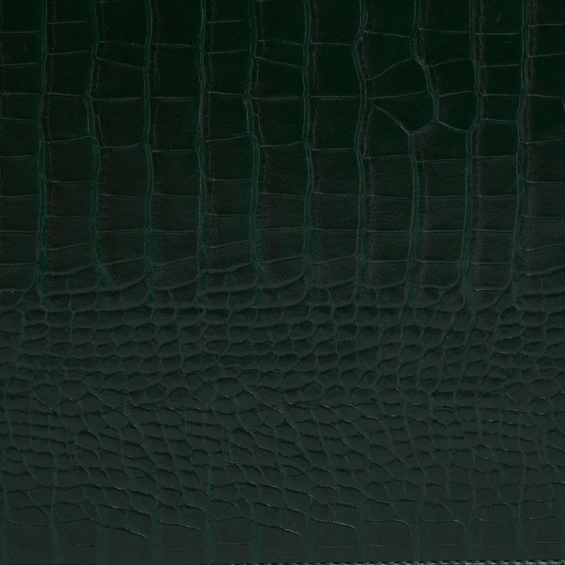 Close-up of dark forest-green crocodile-effect texture on the Fable England jewellery box exterior