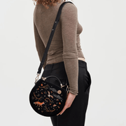 Model wearing Fable England fox and owl black velvet handbag across the body