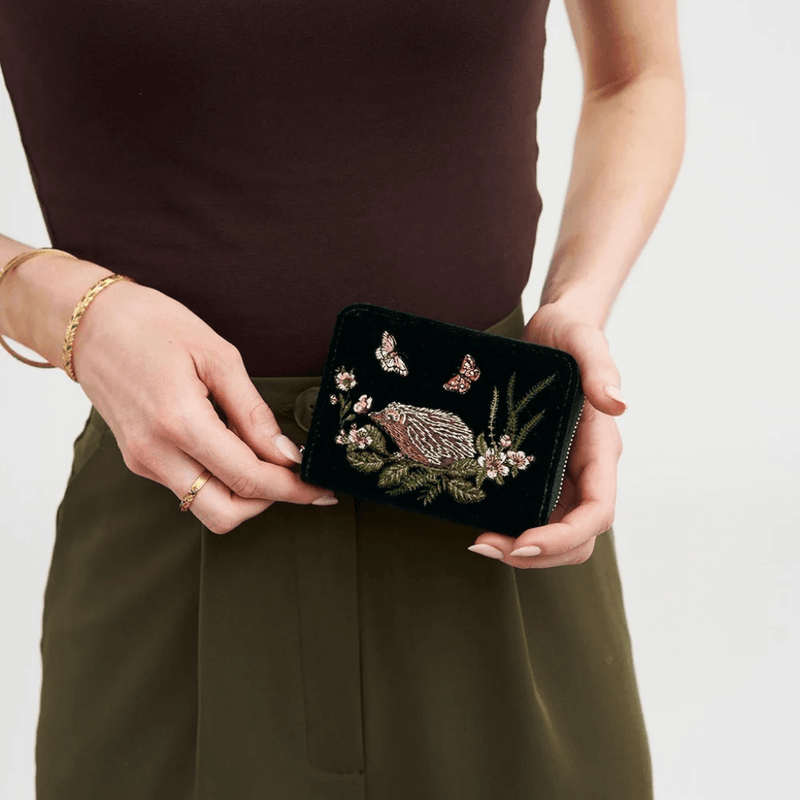 Woman holding Fable England green velvet hedgehog purse showing its compact size