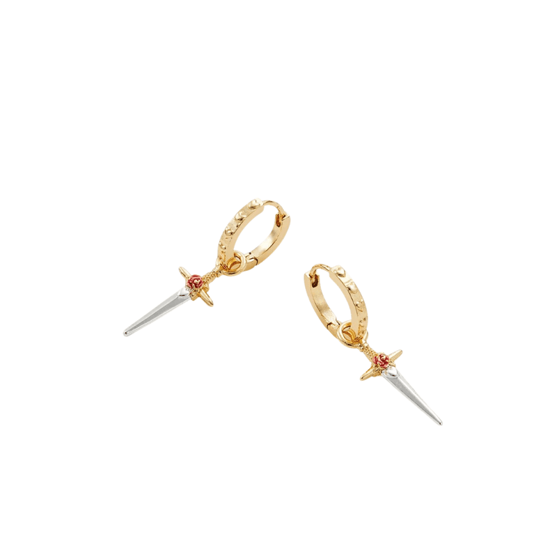 Detailed view of rose and dagger charms suspended from gold hinged hoop earrings