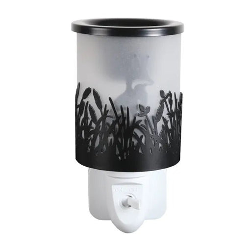Black plug in wax melt burner unlit with frosted panel and cut-out grass design, showing the fox silhouette in the background.
