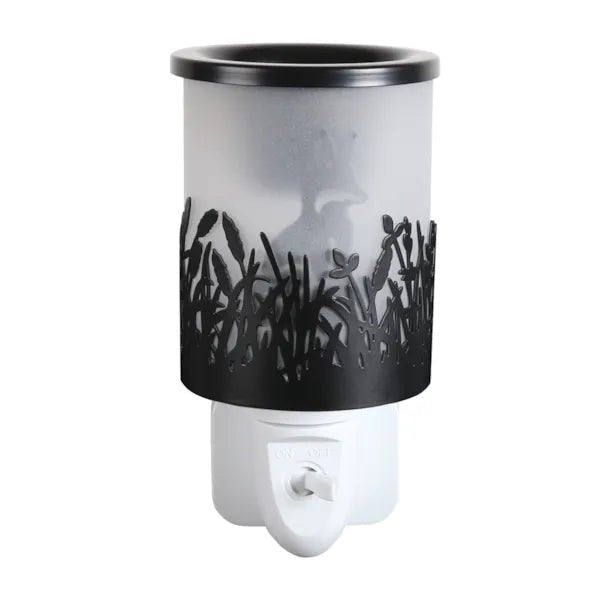 Black plug in wax melt burner unlit with frosted panel and cut-out grass design, showing the fox silhouette in the background.