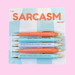 Fun Club Sarcasm Pen Set with 5 black ink ballpoint novelty pens featuring sarcastic quotes on pastel blue and orange packaging