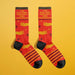 Laid flat red and yellow socks with celestial design and motivational spite slogan, perfect novelty gift for women.

