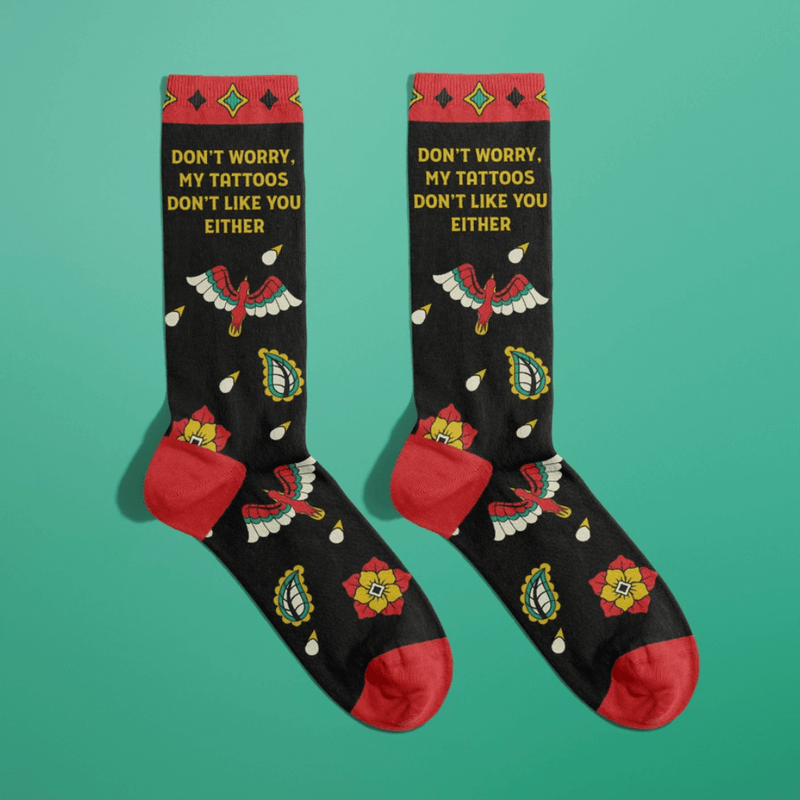 Black women's crew socks with tattoo style eagle and flowers and the phrase Don't Worry My Tattoos Don't Like You Either