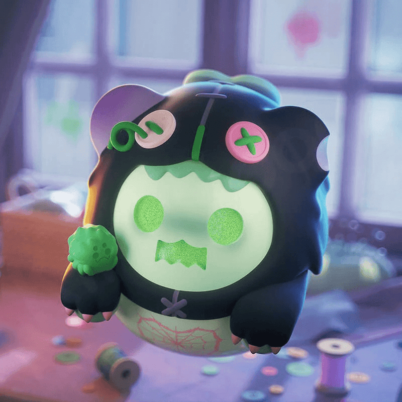 Ghost Bear in black spider hood with pink button eyes holding green heart pincushion.
