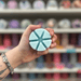 Ghost Flower wax melt segments held in hand with colourful wax melt display in the background
