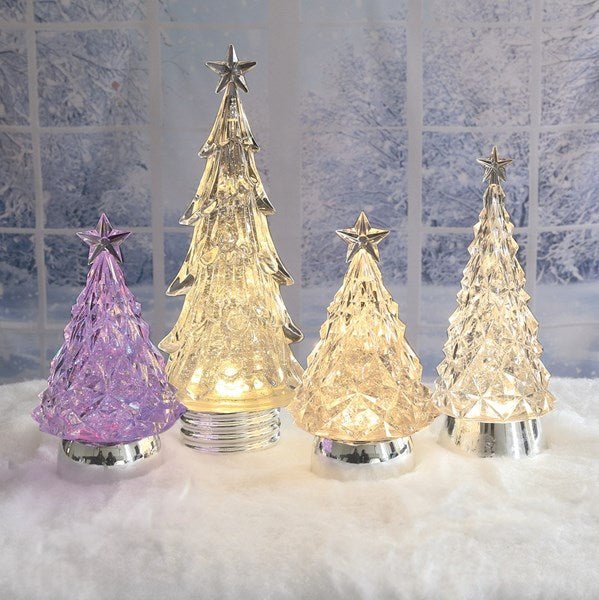 Group scene of illuminated LED Christmas tree water spinner decorations on a snowy surface with a winter window backdrop.