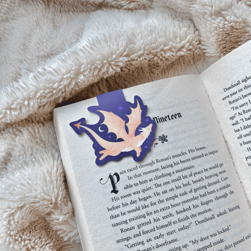Gold Dragon magnetic bookmark clipped securely over the page of an open book