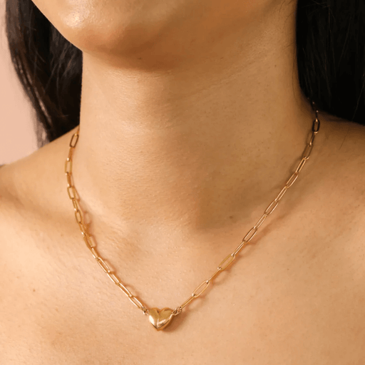 Close-up of gold magnetic heart pendant necklace on the neckline