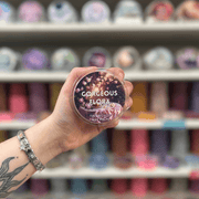 Gorgeous Flora wax melt pot held in hand with colourful wax melt display in the background