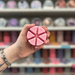Gorgeous Flora wax melt segments held in hand with colourful wax melt display in the background