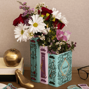 Grimm’s Fairy-Tale triple book vase styled with mixed flowers with golden apple and golden shoe decor