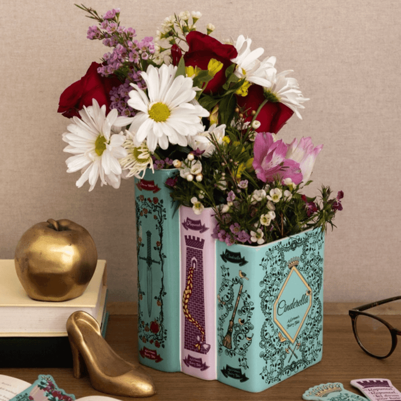 Grimm’s Fairy-Tale triple book vase styled with mixed flowers with golden apple and golden shoe decor