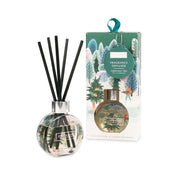 Heart & Home Christmas Tree reed diffuser in clear round glass with black reeds beside the illustrated green gift box with ribbon hanger.