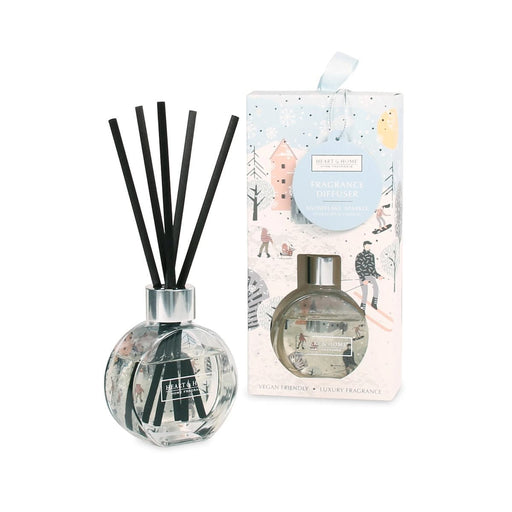 Heart & Home Snowflake Sparkle reed diffuser beside its pale blue illustrated gift box with ribbon hanger; clear round bottle with black reeds.