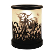 Highland cow silhouette electric wax melt burner glowing warmly with black meadow cut-out detailing.
