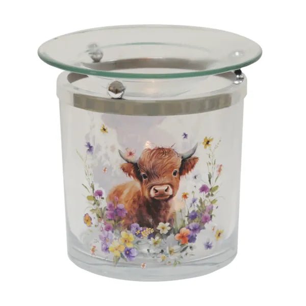 Highland cow glass wax melt burner shown lit with a soft glow beneath the dish.