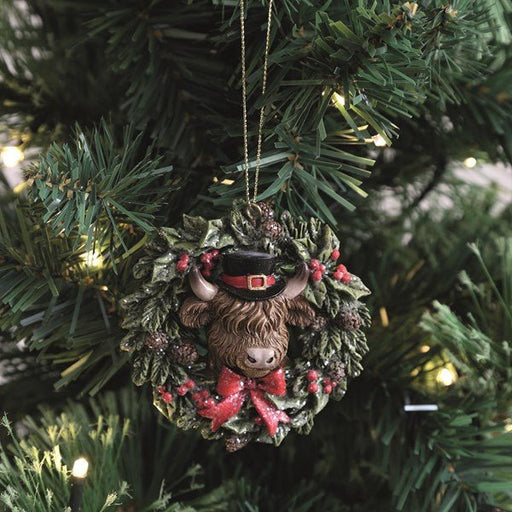 Highland Cow wreath ornament hanging on a lit Christmas tree, 8cm.

