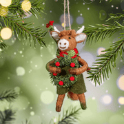 Highland cow holding a festive wreath felt decoration hanging on a Christmas tree