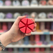 Hot Apple Pie wax melt segments held in hand with colourful wax melt display in the background