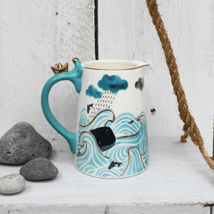 Lifestyle photo of the jug styled with rope and stones, highlighting the wave print