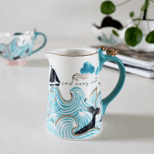 Jug on a table setting showing the gold origami boat on the handle and nautical design