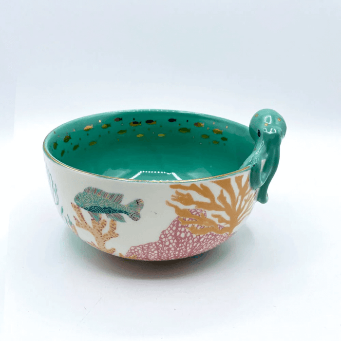 Angled view of the porcelain bowl focusing on the octopus rim detail and teal interior