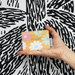 House of Disaster Moomin floral card holder held in hand showing the pastel floral back design