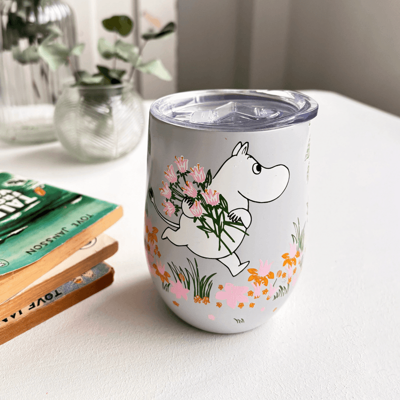 House of Disaster Moomin Floral keep cup on a table with Moomin holding pink flowers and a clear lid