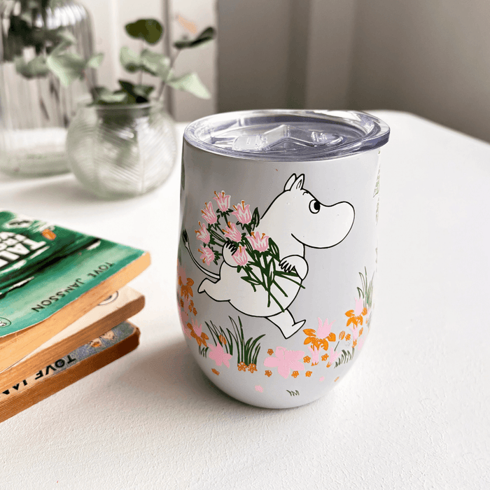 House of Disaster Moomin Floral keep cup on a table with Moomin holding pink flowers and a clear lid