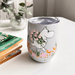 House of Disaster Moomin Floral keep cup on a table with Moomin holding pink flowers and a clear lid