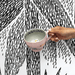 House of Disaster Moomin Love cup held in hand showing the grey interior and hidden Moomin figure inside