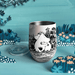 Front lifestyle view of open House of Disaster Moomin Love keep cup with lid beside the tumbler in a blue floral scene