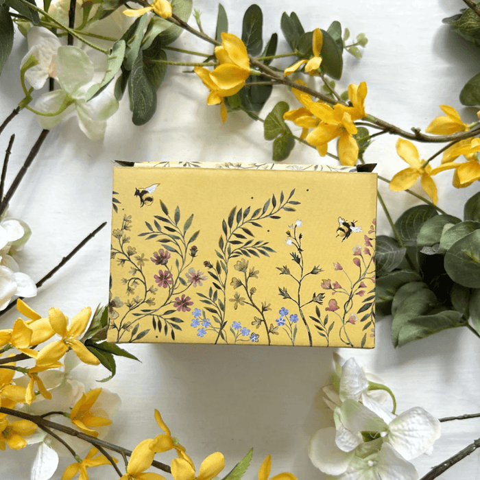 Back of the gift box featuring floral illustrations on a yellow background