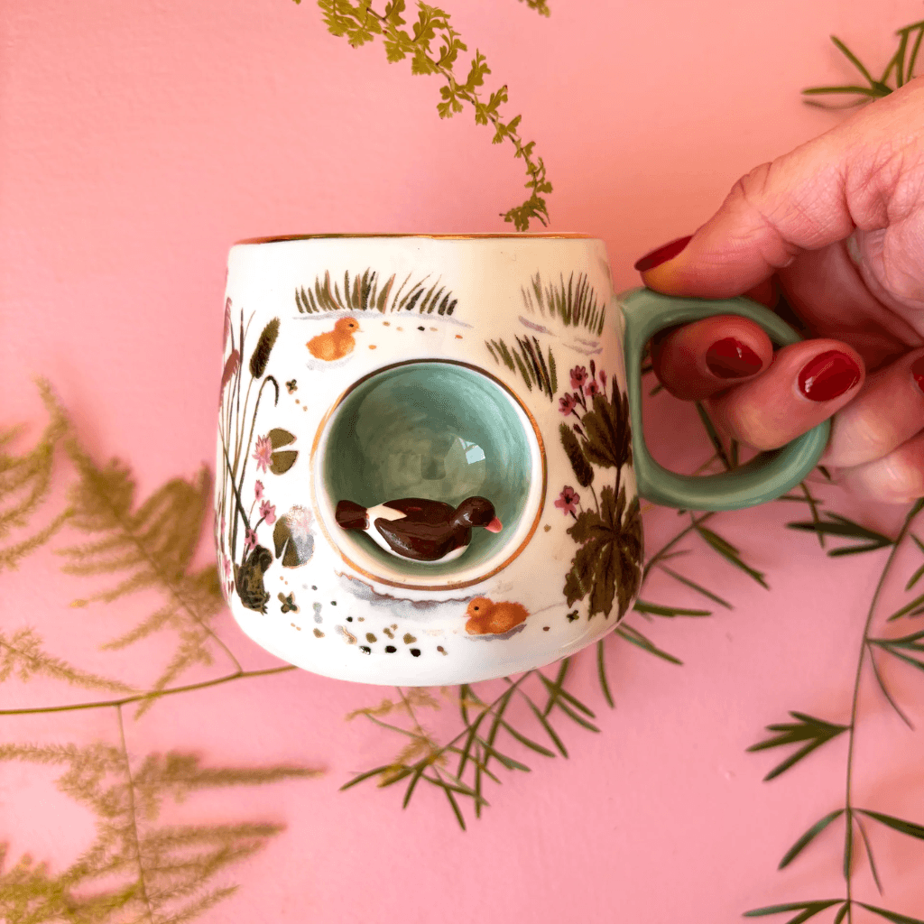 Hand holding the House of Disaster Secret Garden 3D Duck Mug