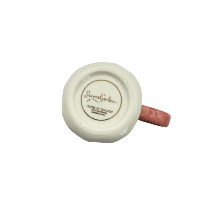 Base of the cup showing Secret Garden branding and handwash-only care details