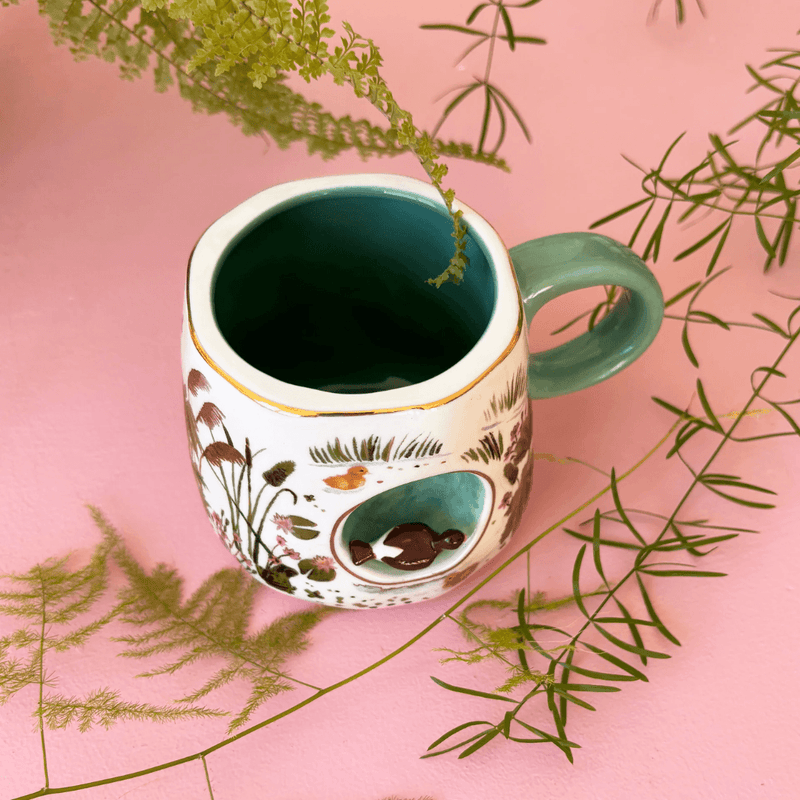 Secret Garden Duck Mug displayed with foliage showing the teal interior and 3D duck