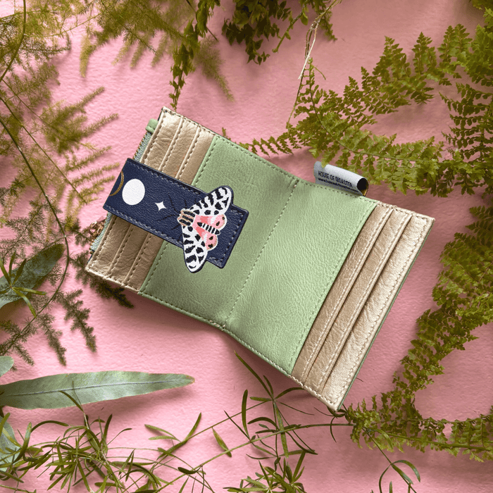 House of Disaster Secret Garden Moth Purse open, showing interior card slots on pink background