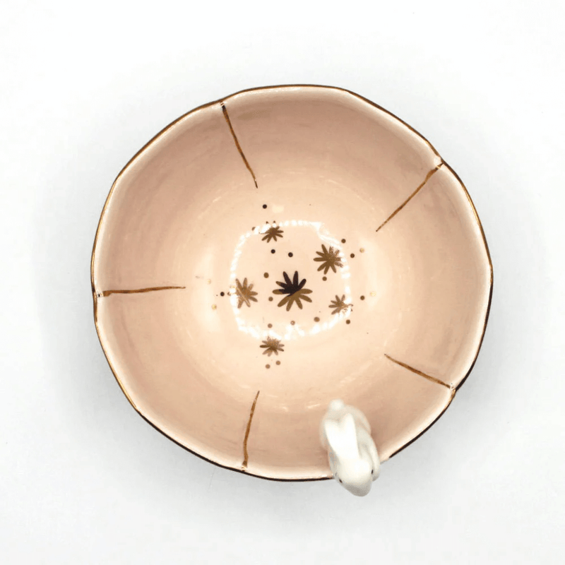 Top view of the blush flower-shaped bowl showing gold detailing inside and rabbit detail on the rim