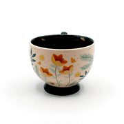 Front view of the cup showing floral illustrations, gold details and teal interior