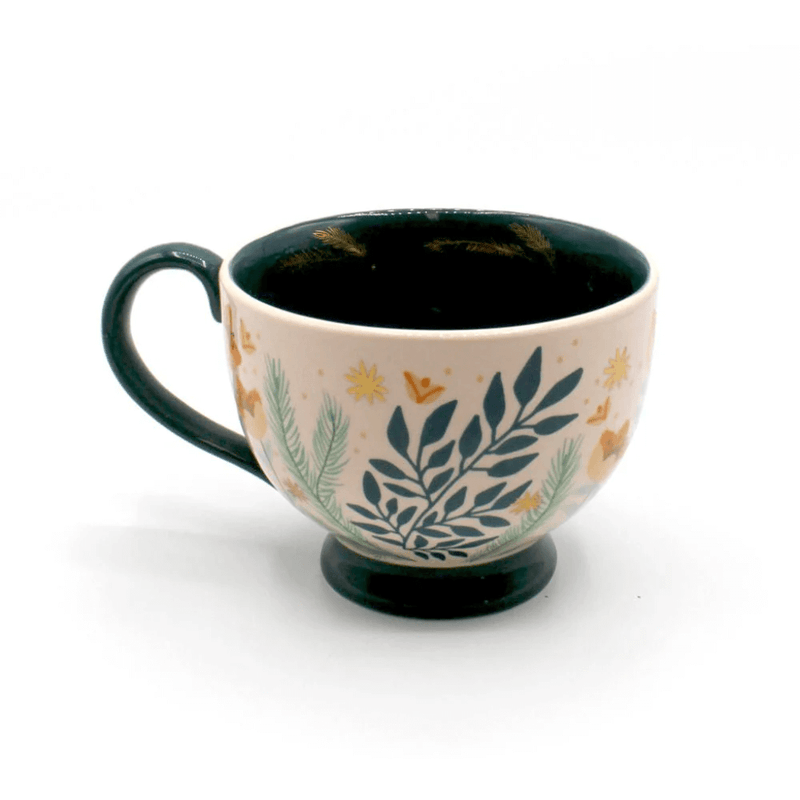 Side view of the porcelain teacup with foliage print, soft pink glaze and teal handle