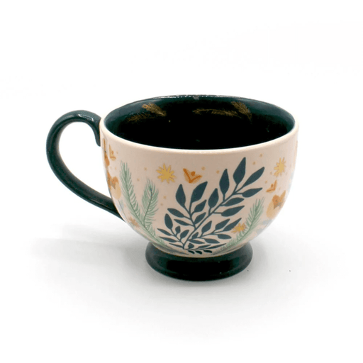 Side view of the porcelain teacup with foliage print, soft pink glaze and teal handle