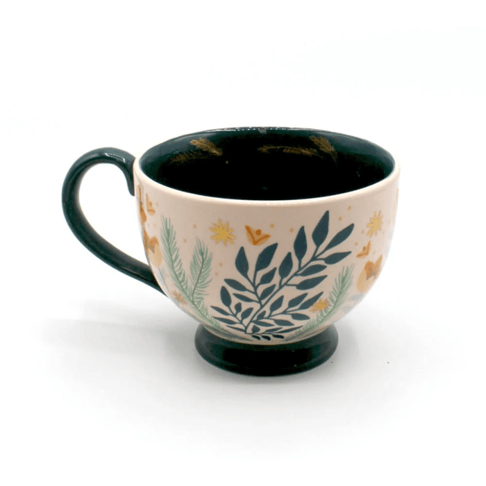 Side view of the porcelain teacup with foliage print, soft pink glaze and teal handle