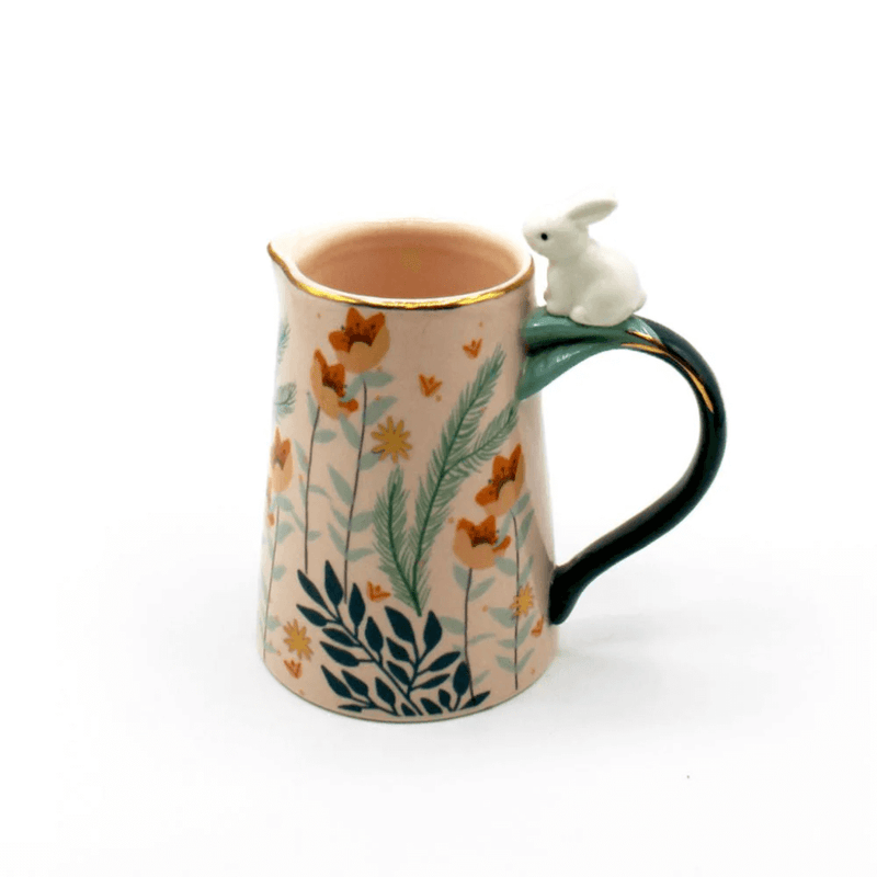 Front view of the pink porcelain jug with foliage print and rabbit perched on the handle