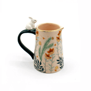 Side view showing the handle, rabbit detail and soft pink glaze