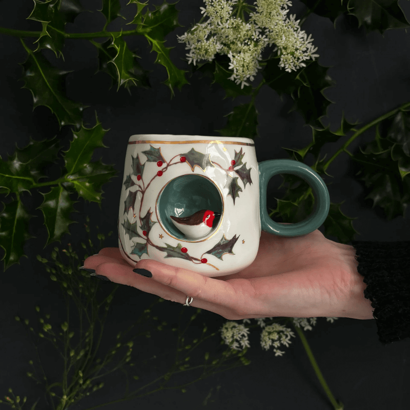 Robin Cup resting on a hand, highlighting the 3D robin detail and gold-foil rim